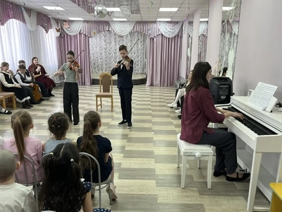 Дети из школы искусств играют на музыкальных инструментах