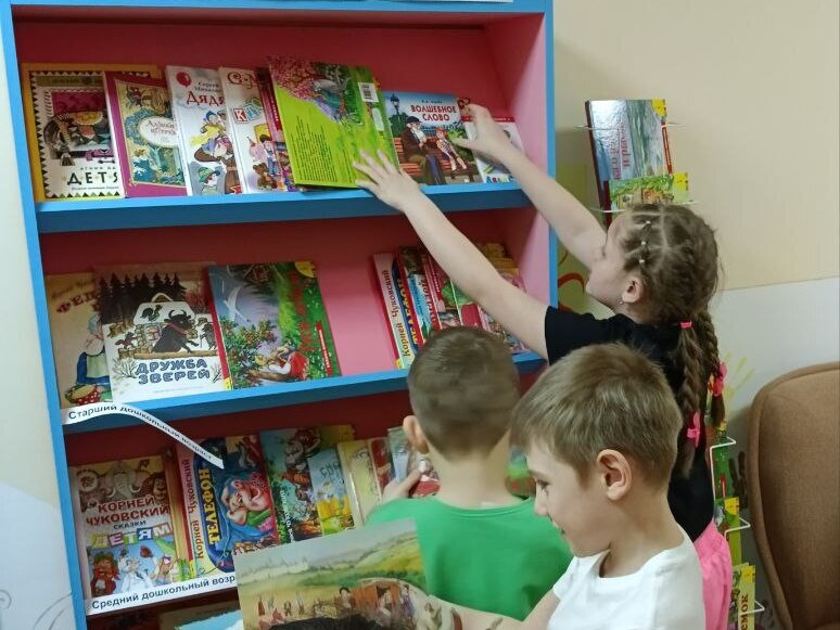 Дети выбирают на выставке литературы понравившуюся книгу